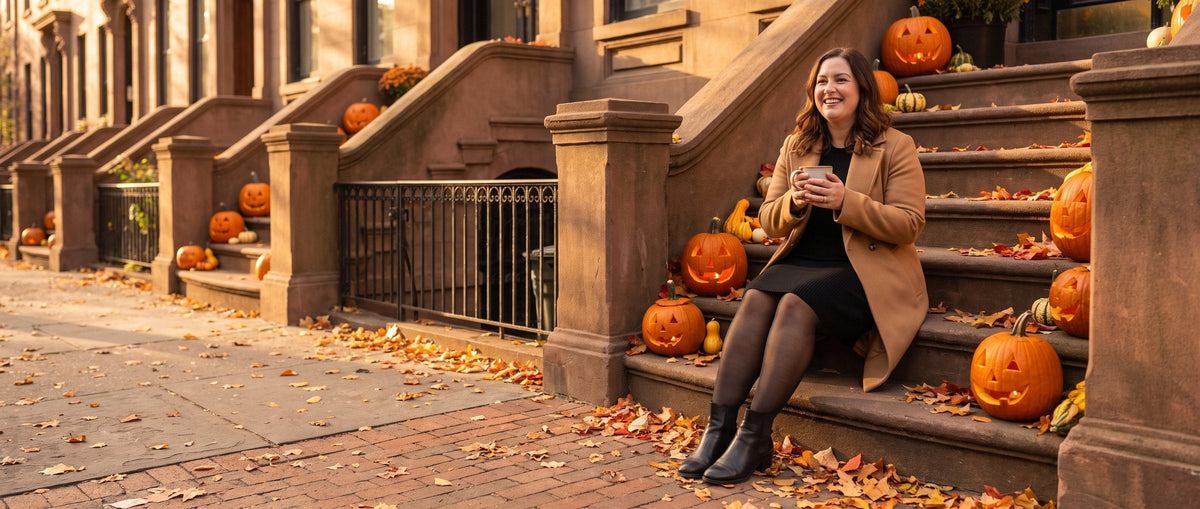 Woman in sheer-look fleece-lined tights sitting on a brownstone stoop with jack-o’-lanterns